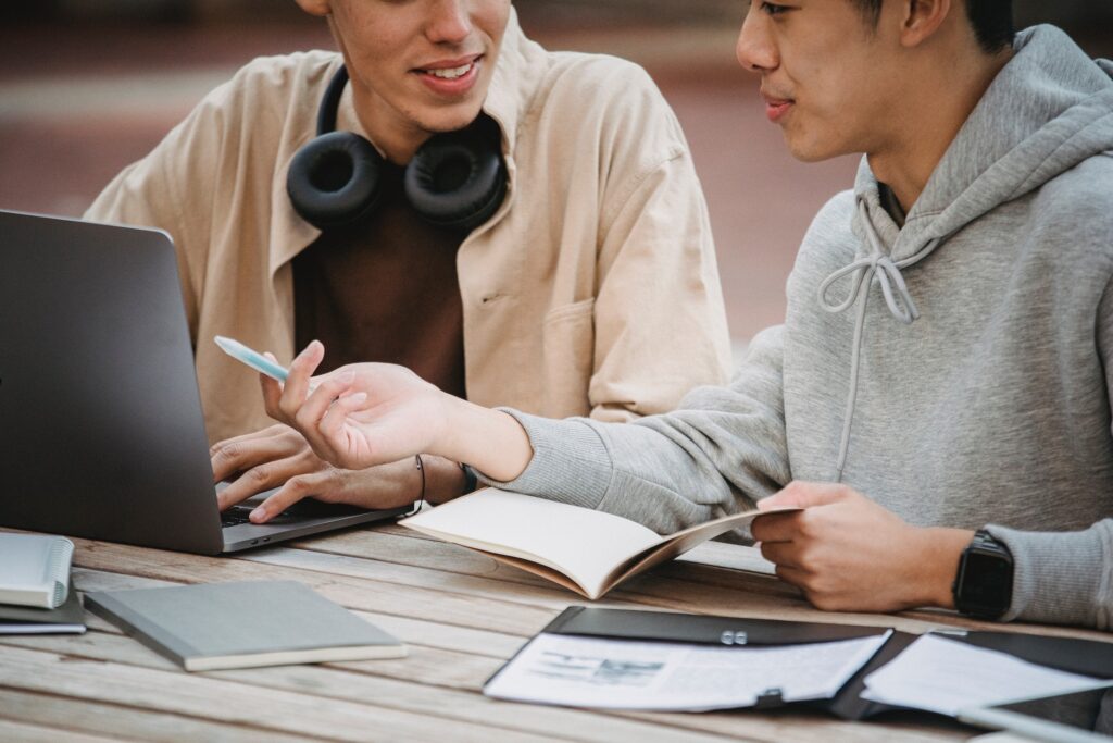 Dos personas conversando delante de un portatil